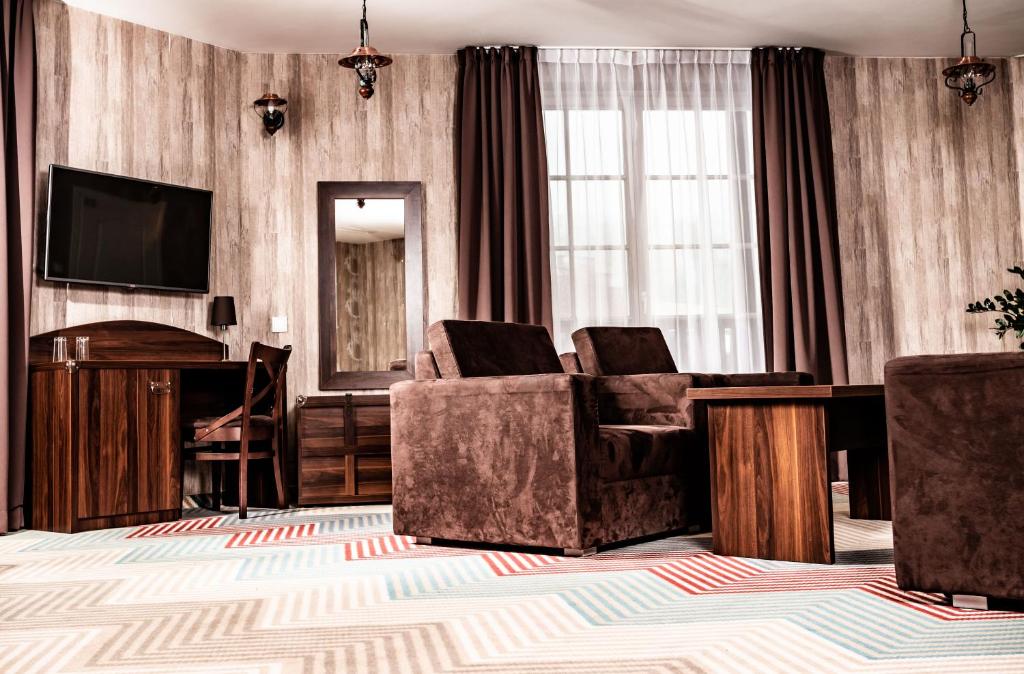- un salon avec deux chaises et une télévision dans l'établissement Hotel Texas***, à Żory