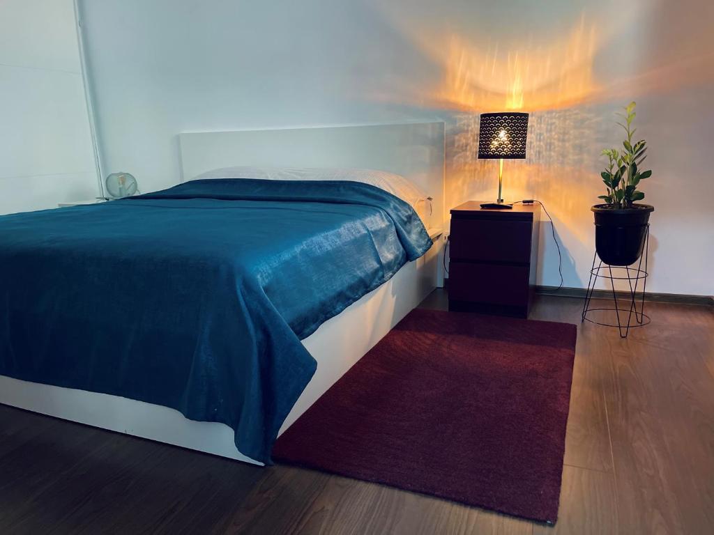 um quarto com uma cama, um candeeiro e um tapete em City Garden Apartments em Bucareste