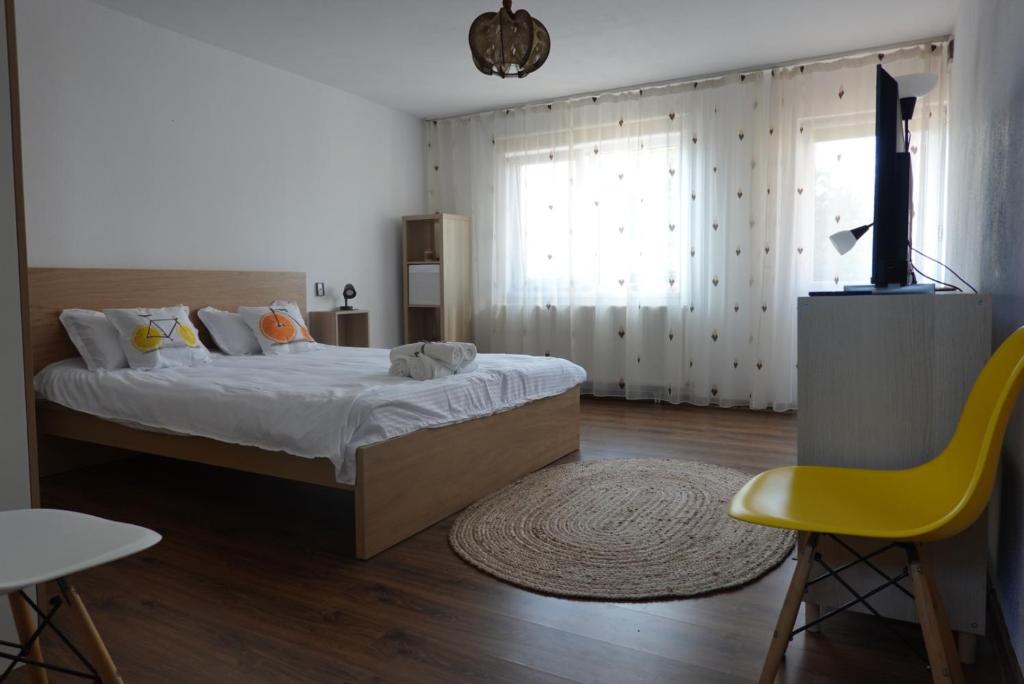 um quarto com uma cama e uma cadeira amarela em Dynamic Bike Home em Curtea de Argeş