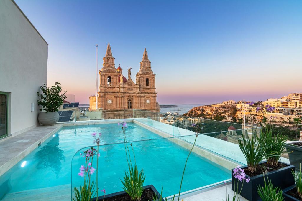 a building with a swimming pool in front of a building at DOMS Boutique Living in Mellieħa