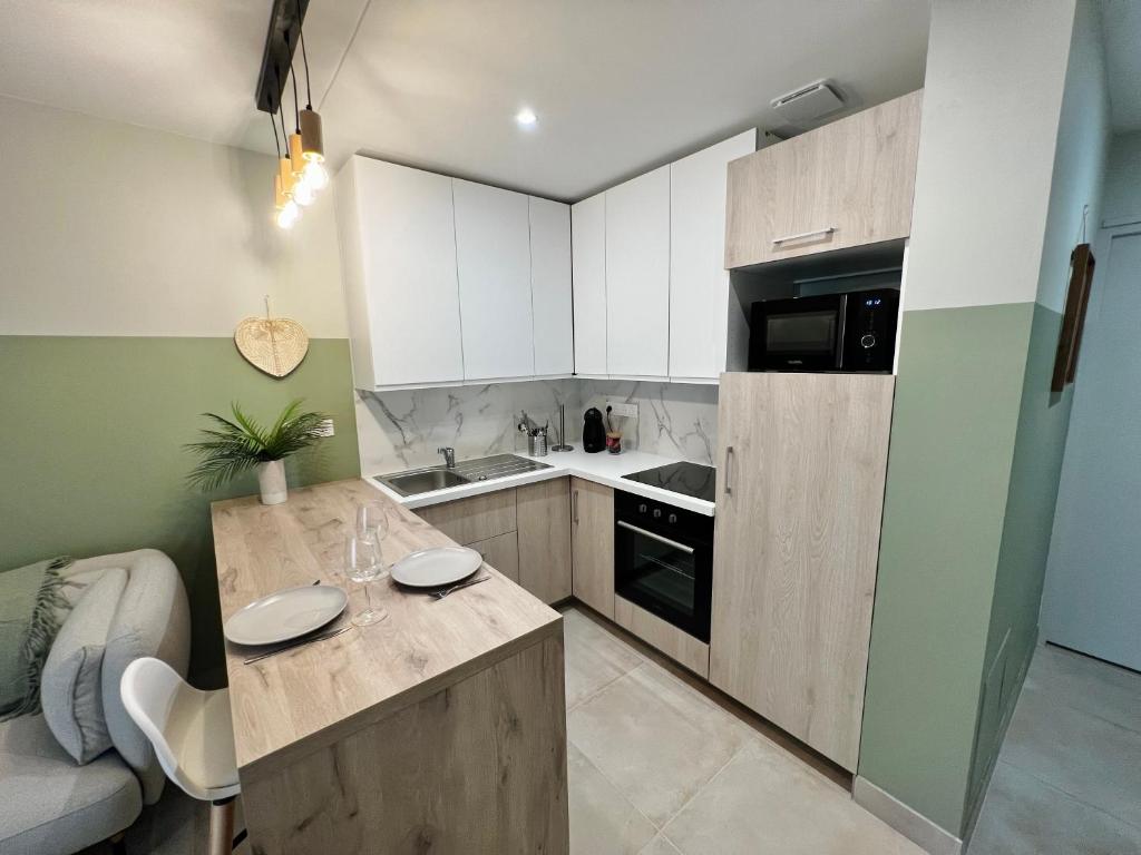 una cucina con armadi bianchi e piano di lavoro di Appartement cosy - Trégastel a Trégastel