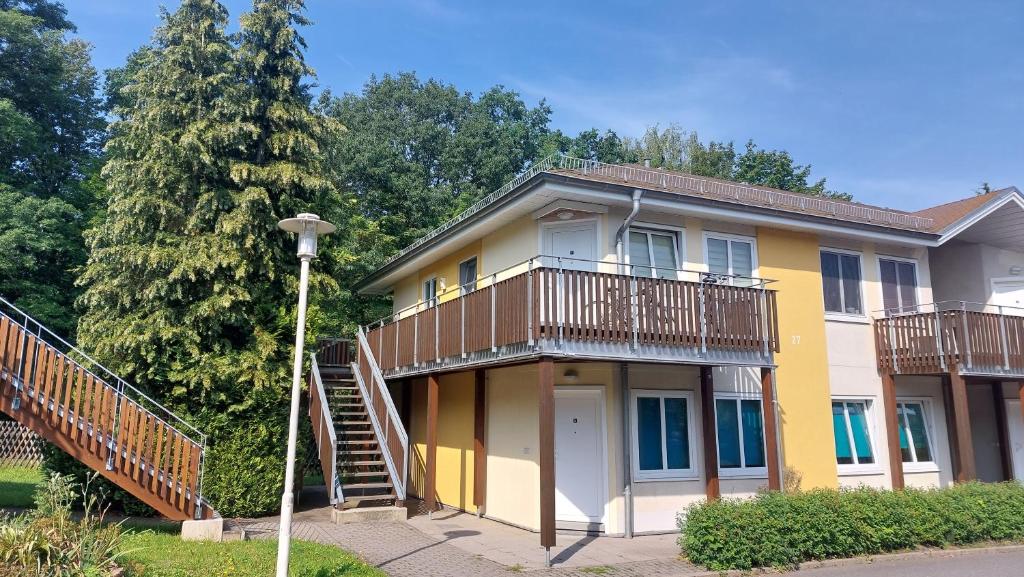 a yellow house with a staircase in front of it at Ferienwohnung Teichblick in Freiberg