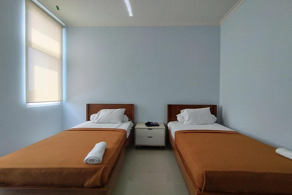 Postel nebo postele na pokoji v ubytování Hotel Sutha Inn Syariah