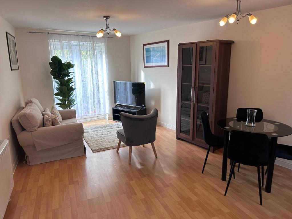 a living room with a couch a table and a tv at Mikky property in Purfleet