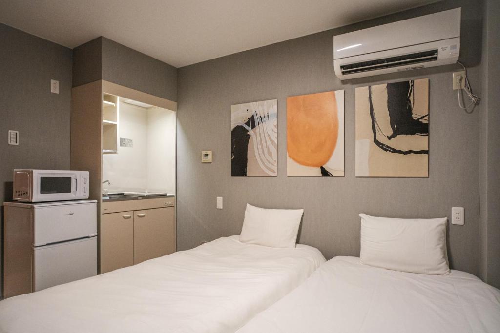 a hotel room with two beds and a microwave at 殿堂 in Tokyo
