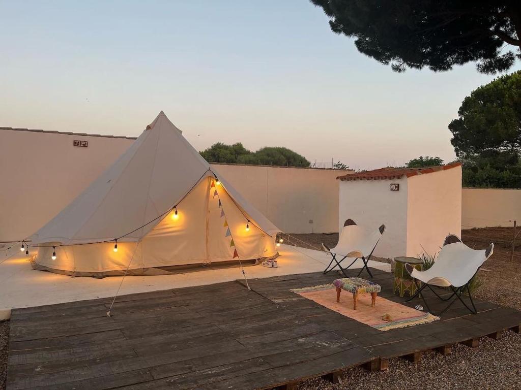 a tent with lights and two chairs on a deck at CÁDIZ -TIPI en Chiclana de la frontera, España in Chiclana de la Frontera