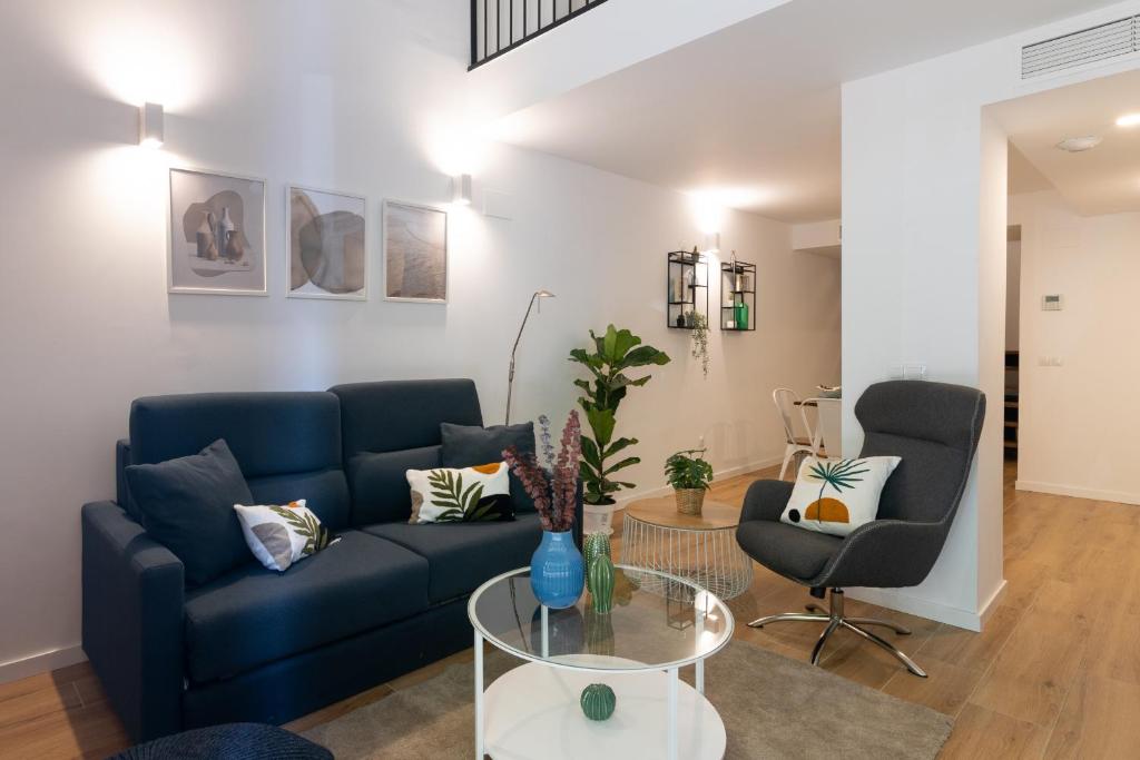 sala de estar con sofá azul y mesa de cristal en DormForYou Alameda 12 Apartment, en Valencia