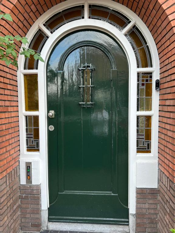 een groene deur in een bakstenen gebouw met een raam bij High Street Haven in Eindhoven