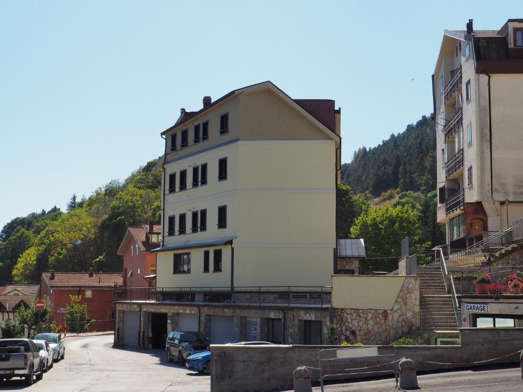 un grand bâtiment blanc sur le côté d'une rue dans l'établissement I Narcisi, à Roccaraso