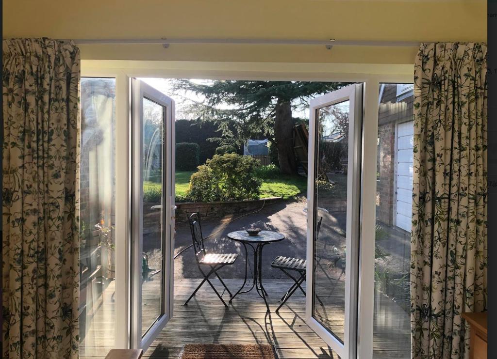 an open door to a patio with a table and chairs at Brindles in Sissinghurst