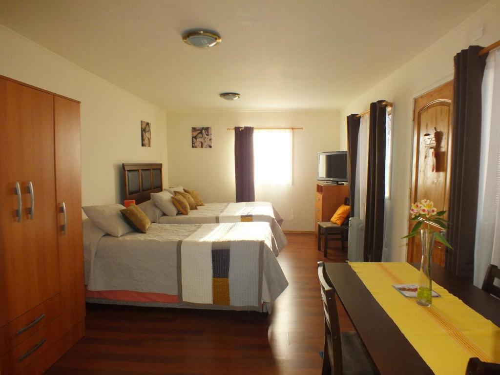Hostal Miramar في فالبارايسو: غرفة فندقية بسريرين ونافذة