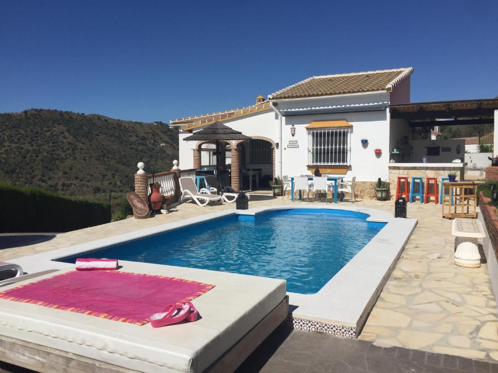 eine Villa mit einem Pool vor einem Haus in der Unterkunft Villa Casira met 2 studio's - 10 personen, Viñuela, Costa Del Sol in Viñuela
