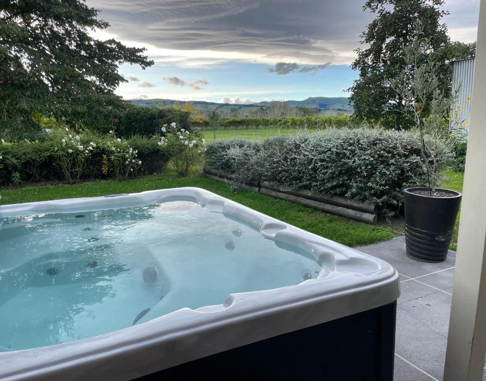 a jacuzzi tub in the yard of a house at Cosy Cottage in the Vines in Waipara