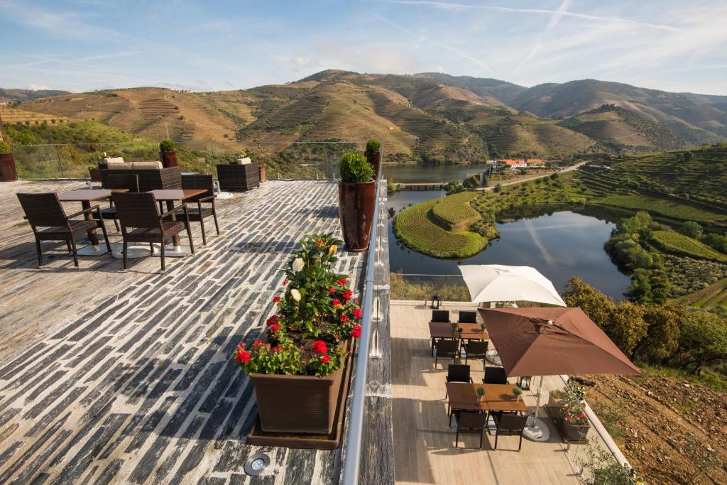 a patio with a view of a lake and mountains at Vila Gale Douro Vineyards in Armamar