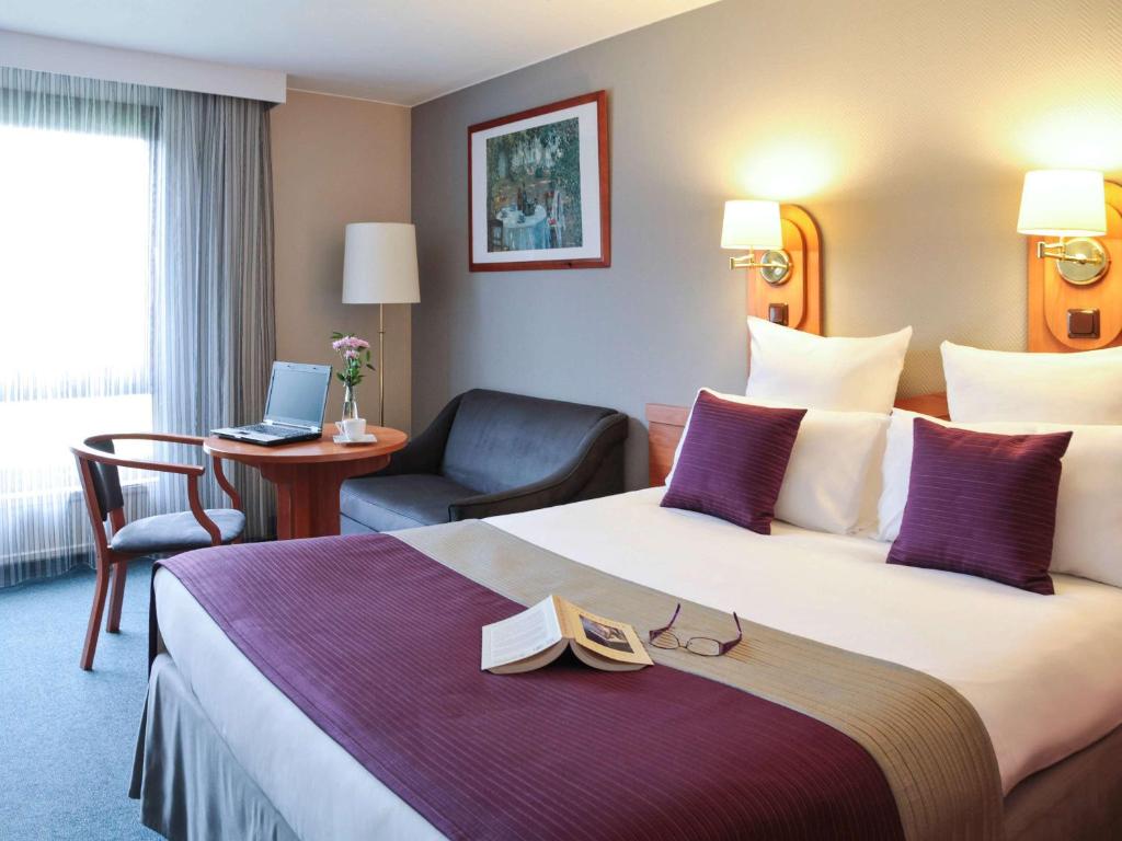 - une chambre d'hôtel avec un grand lit et un livre dans l'établissement Mercure Cieszyn, à Cieszyn