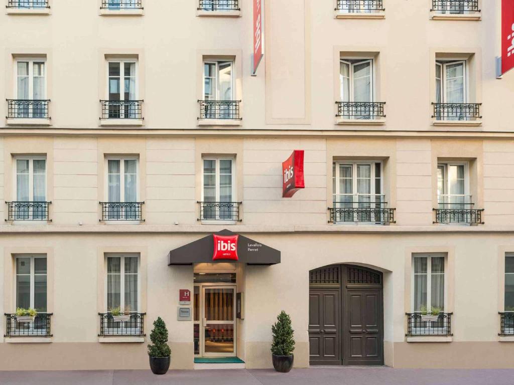 a facade of a building with a berg hotel at ibis Levallois Perret in Levallois-Perret