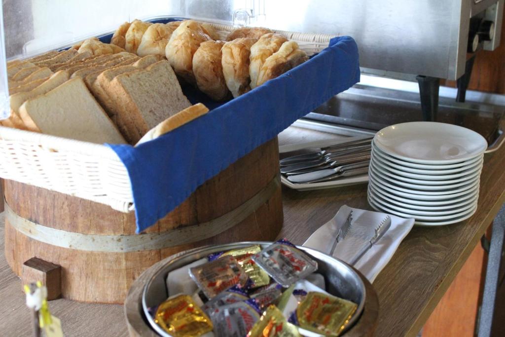 a table with a basket of bread and a plate of food at Deva Beach Resort Samui in Choeng Mon Beach