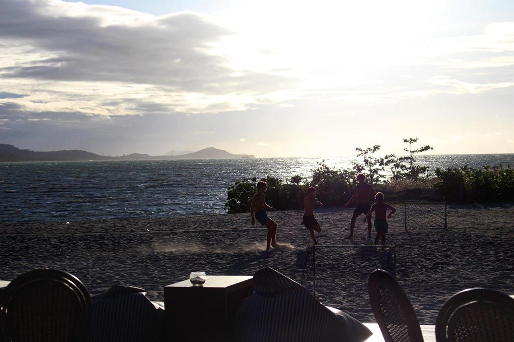 a group of people playing soccer on the beach at Deva Beach Resort Samui in Choeng Mon Beach