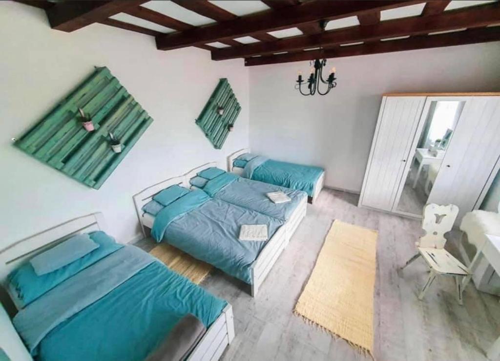 1 dormitorio con 2 camas y sofá en Tulipános Vendégház, en Igrici