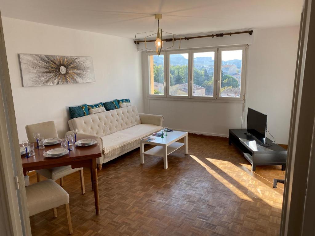 a living room with a couch and a table at Appartement calme Stade/plage in Marseille