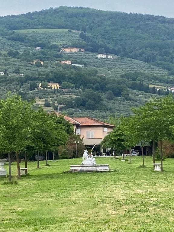 eine Statue inmitten eines Feldes mit Bäumen in der Unterkunft Campagna Toscana - A casa di Vale in Pistoia
