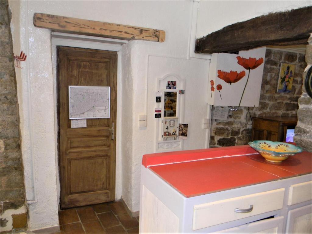 ロルグにあるAtypique-ancienne grange de 48 m²の赤いカウンタートップとドア付きのキッチン