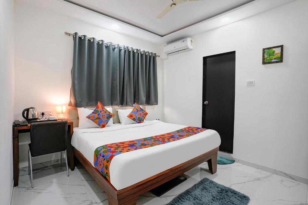 a bedroom with a bed and a desk and a window at FabHotel Fortuna Inn in Navi Mumbai