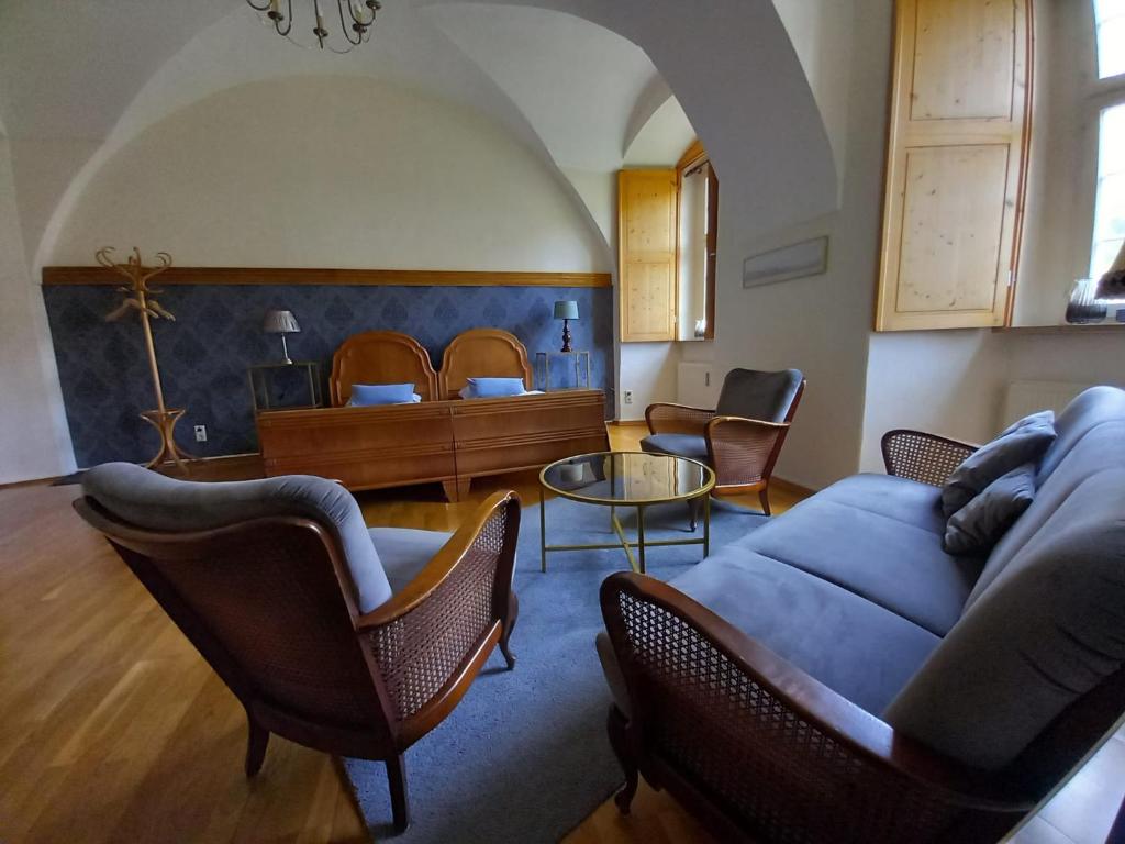 ein Wohnzimmer mit einem Sofa, Stühlen und einem Bett in der Unterkunft Klostermühle in Lichtenfels