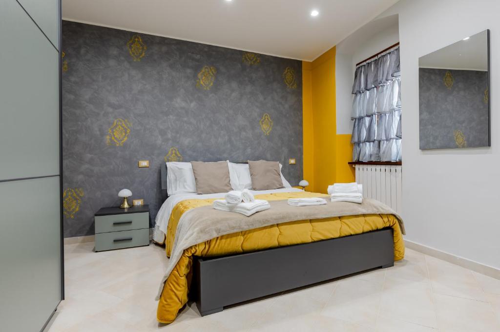 um quarto com uma cama com uma parede amarela e cinzenta em Dama Rossa Foligno Central Aparment em Foligno