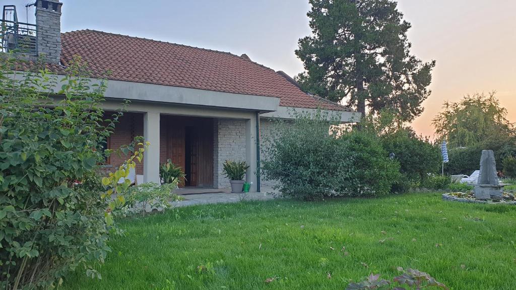 uma casa com um jardim verde com um campo de relva em Villa Martini dei Rossi em Sanfrè