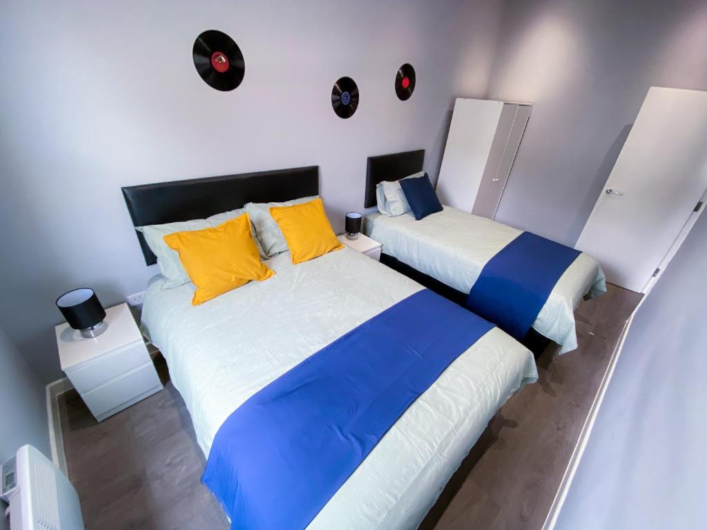 2 camas en una habitación de color blanco y azul en MODERN 1 BEDROOM FLAT IN WOOD GREEN en Londres