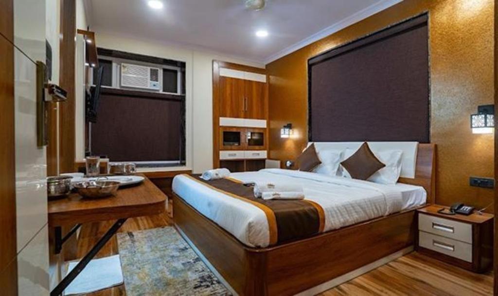 a bedroom with a bed with a desk and a sink at FabHotel Prime Tiyara Inn in Kolkata