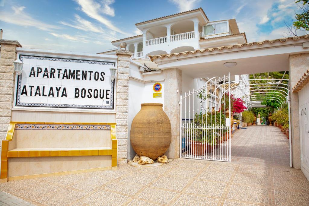 パゲラにあるAtalaya Bosque Apartamentosの門の横に大花瓶を置いた店