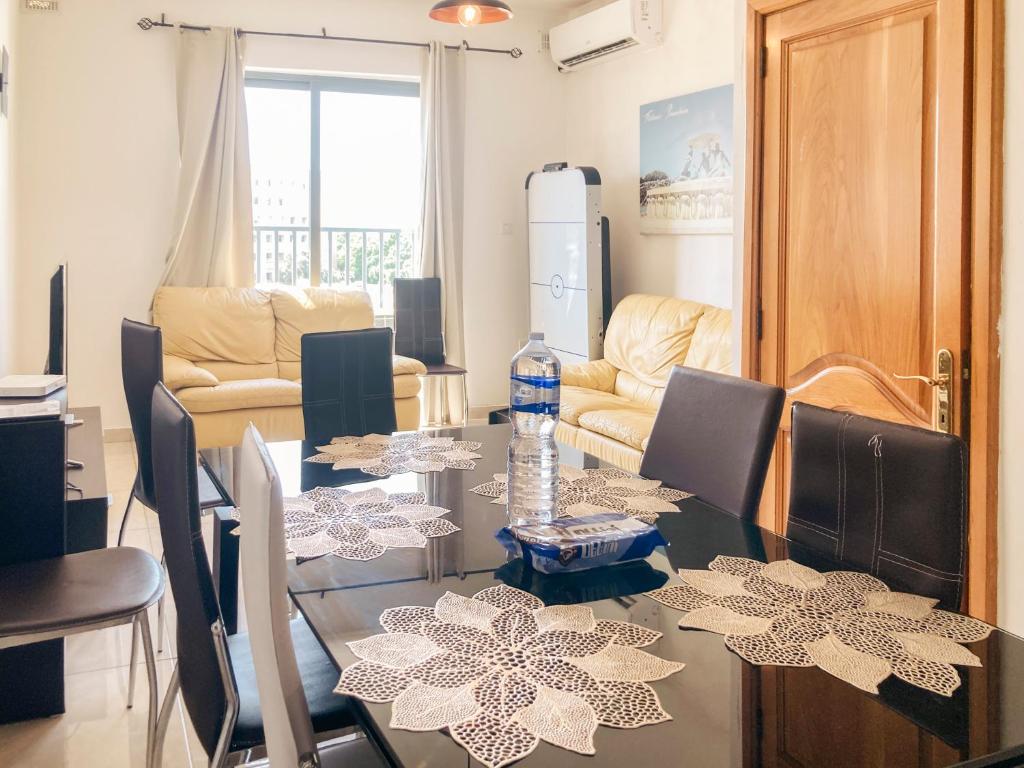 XL Central Home - Sleeps 10 people في Pieta: غرفة طعام مع طاولة وكراسي وغرفة بها