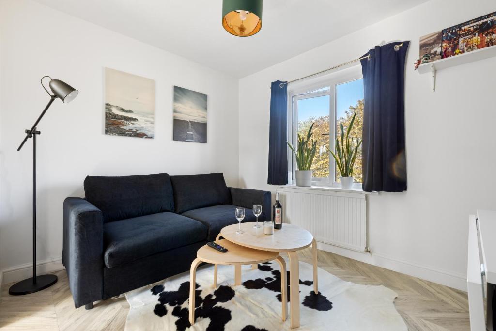ein Wohnzimmer mit einem Sofa und einem Tisch in der Unterkunft Tranquil 1 Bed Flat in East London in London