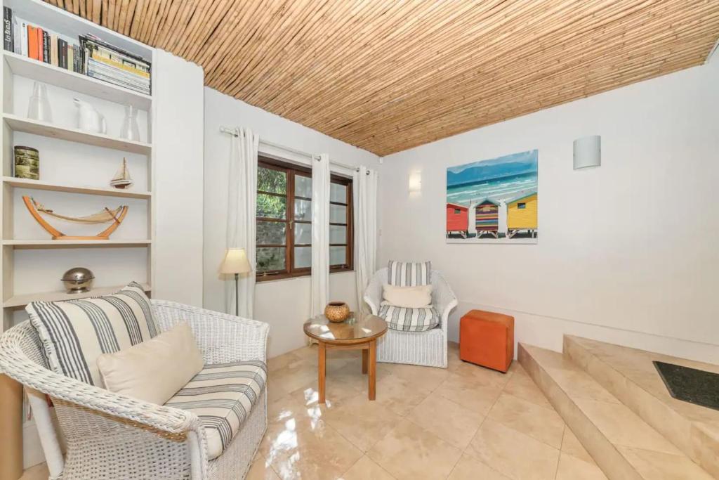 a living room with a couch and two chairs at Tropical 1BD Hideaway near Queens Beach Fresnaye! in Cape Town