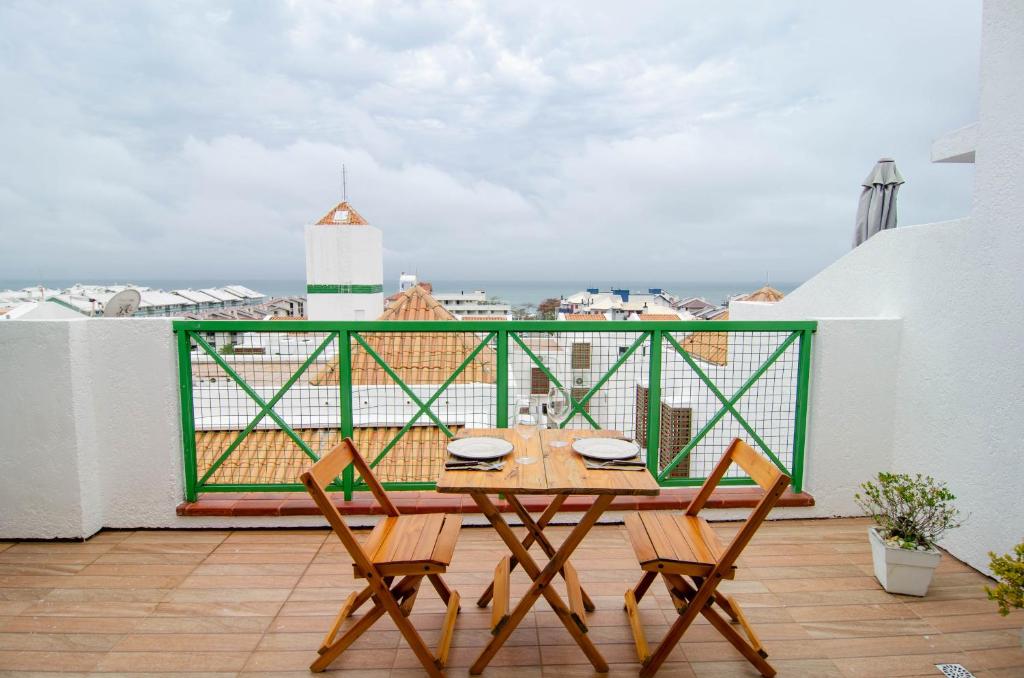 uma mesa e cadeiras numa varanda com vista em Duplex Vista Mar na Praia Brava YF7387 em Florianópolis