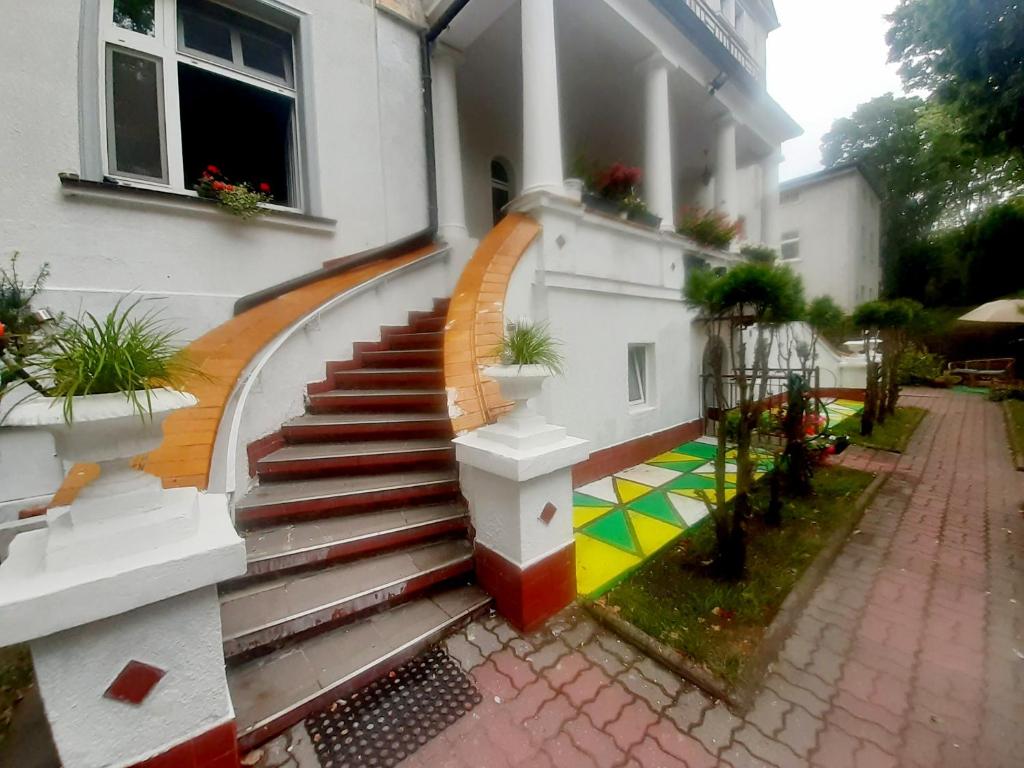 a staircase leading to a house with a colorful floor at Willa Pasja in Inowrocław