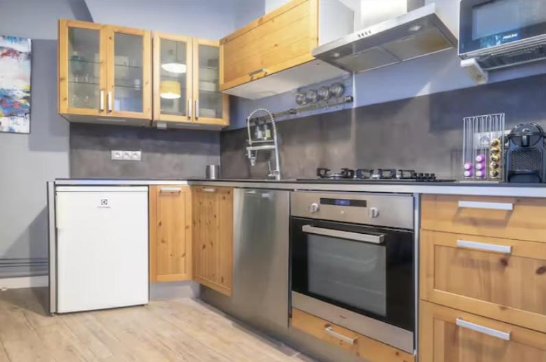 une cuisine avec des appareils en acier inoxydable et des armoires en bois dans l'établissement 36ROS Superbe appartement cosy centre ville, à Marseille