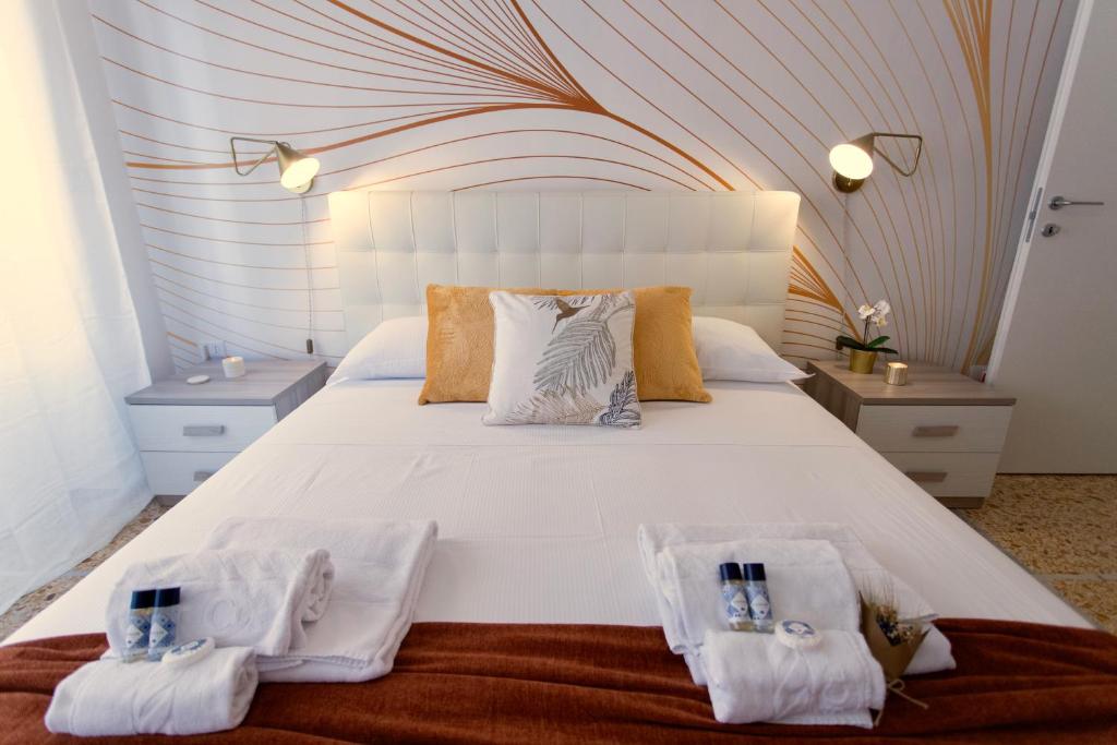 a bedroom with a large white bed with two towels at Elide - Love Locks in Ponte Milvio in Rome