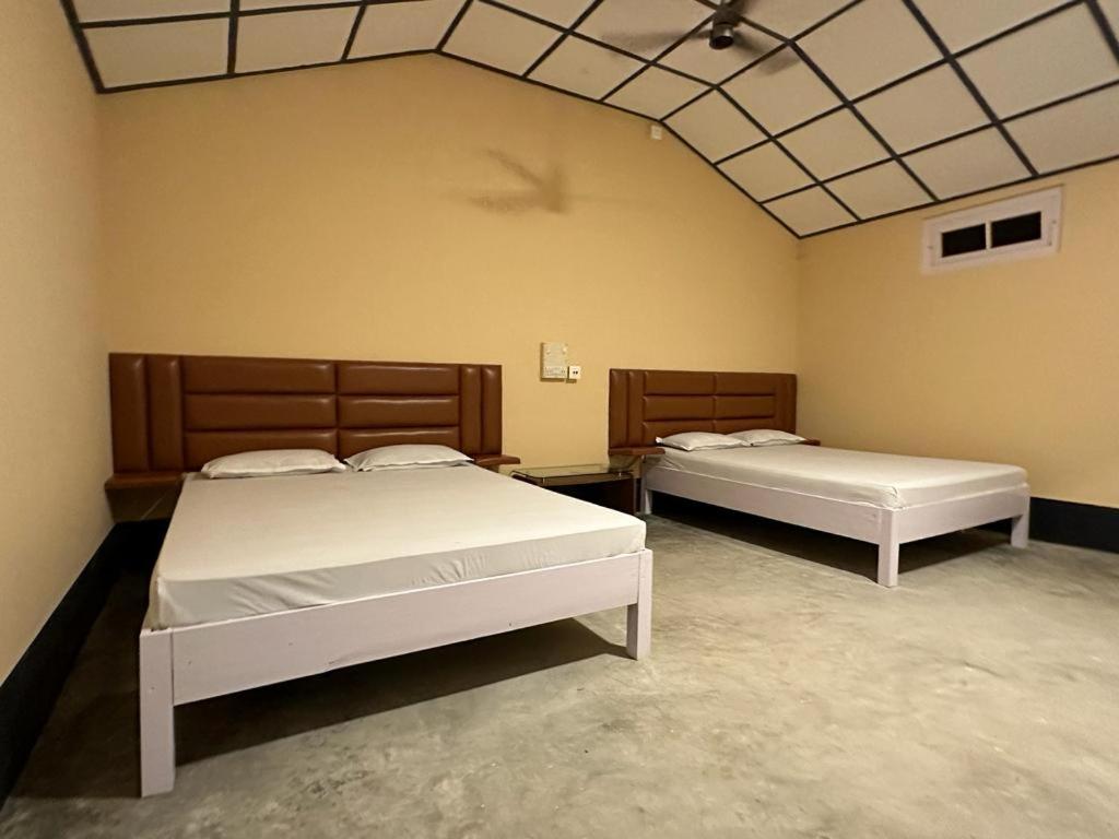 two beds in a room with two beds sidx sidx sidx at Camp Buffalo Retreat in Jyoti Gaon