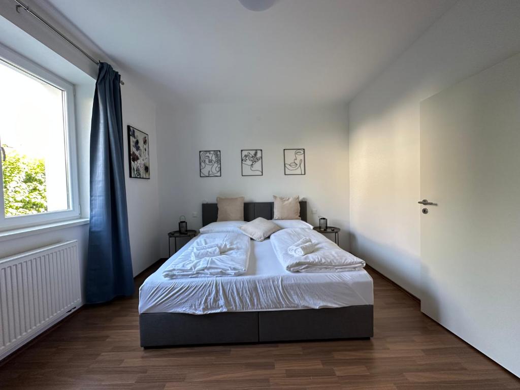 Un dormitorio blanco con una cama grande y una ventana en FeelHome-GolfClub-Terrasse-6 Gäste-WiFi-Smart TV, en Ebreichsdorf