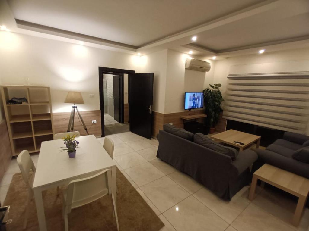uma sala de estar com um sofá e uma mesa em Rimini Furnished Apart. em Amã