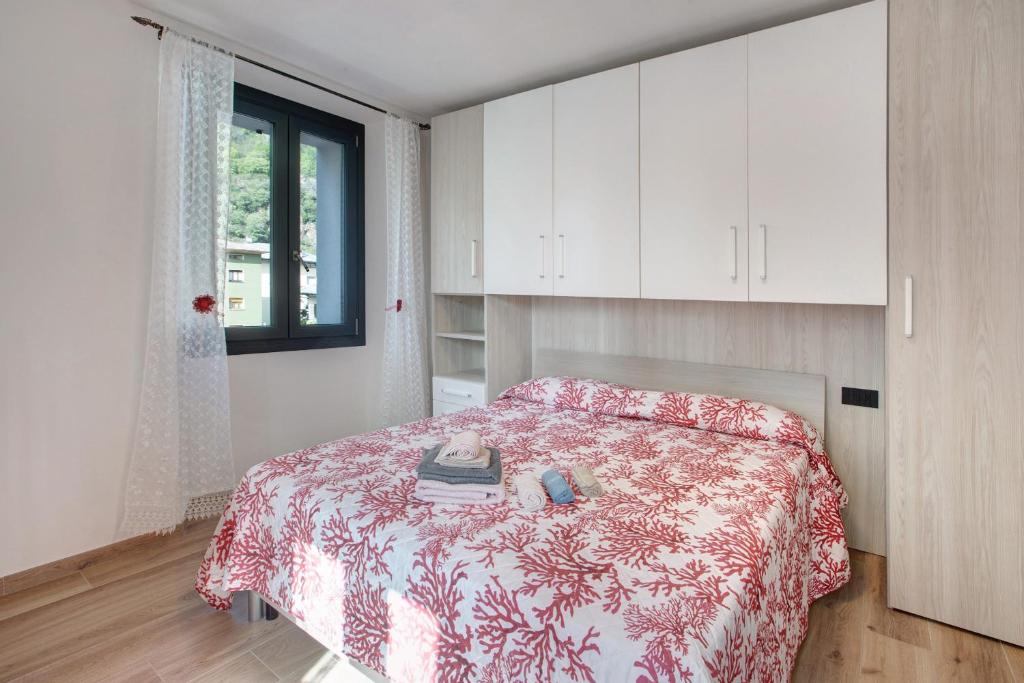 1 dormitorio con 1 cama con manta roja y blanca en Panorama Gaudì, en Grosio