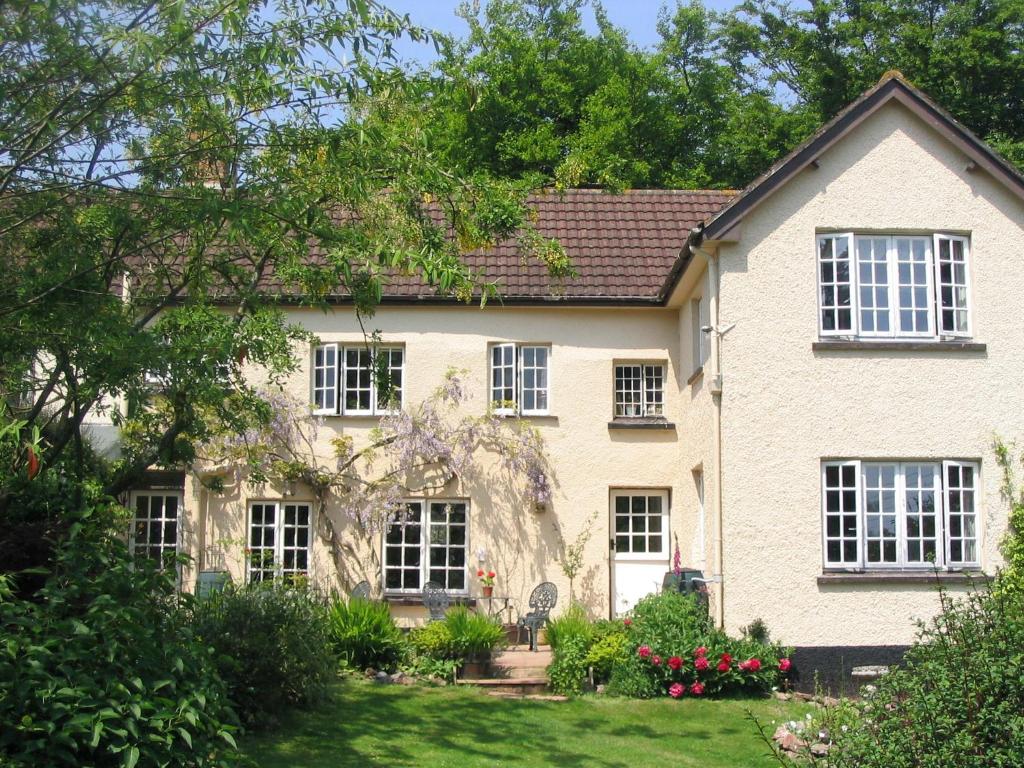 Casa blanca con ventanas blancas y patio en Brambles Bed and Breakfast, en Tiverton