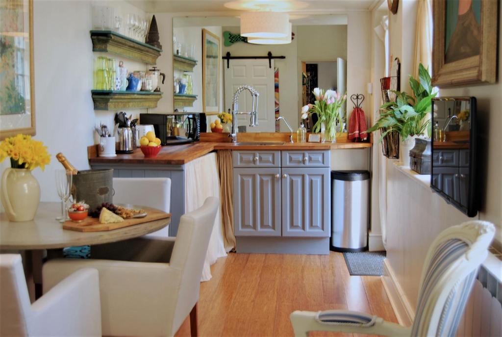 a kitchen with a table and a counter top at Hampton Court Snug Sleeps 6 - 5min Walk to Palace and Train in East Molesey