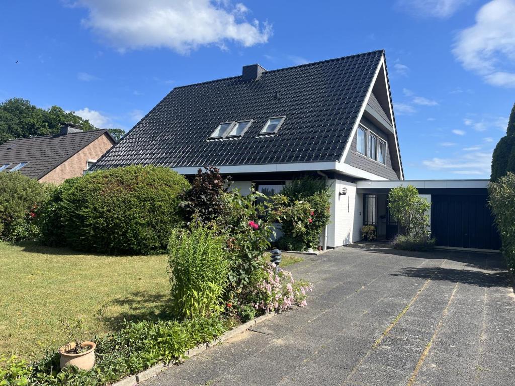 a house with a black roof and a driveway at STOE 14a Gästehaus Iden, App 3 in Niendorf