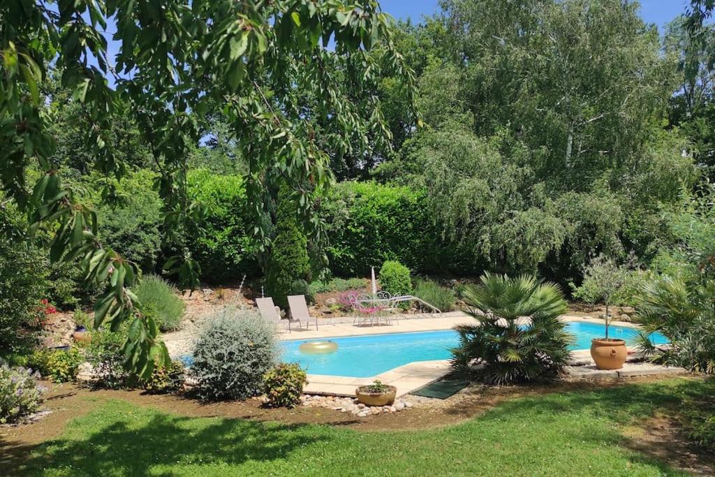 einen Pool in einem Garten mit Bäumen in der Unterkunft Maison d'hôtes Decastela in Thiviers