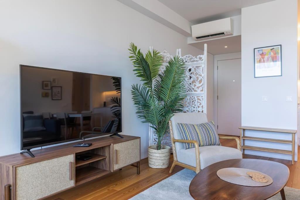 ein Wohnzimmer mit einem großen Flachbild-TV in der Unterkunft Oasis 28 III by Innkeeper in Lissabon