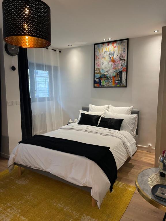 um quarto com uma cama grande e uma pintura na parede em Cosy Studio paris 16 Victor Hugo em Paris